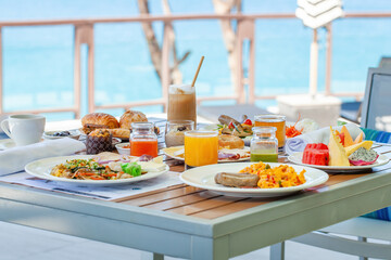 Wall Mural - Breakfast in tropical hotel with sea view. Buffet food in restaurant in modern resort. Concept of travel and summer vacation.