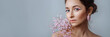 Portrait of a beautiful brunette woman with perfect skin and creative floral makeup look. The concept of cosmetic procedures, women's day. Banner for website header design with copy space.