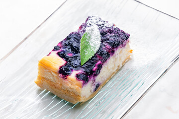 Wall Mural - a piece of blueberry cheesecake on the glass plate