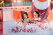 Happy family is quickly sliding on an inflatable circle along the chute from slide. Selective focus on water splash.