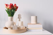 spring home modern decorations with bouquet of tulips, cozy candles and books