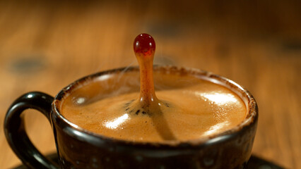 Macro Shot of Coffee Drop Falling into Fresh Espresso Cup