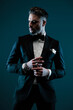 © Viorel Sima - attractive bearded man in elegant tuxedo looking to side and touching fingers