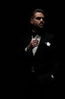 © Viorel Sima - elegant bearded groom wearing black tuxedo and looking to side