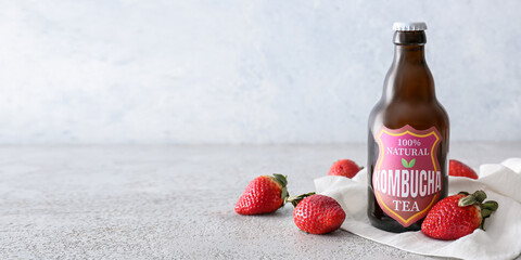 Wall Mural - Bottle of fresh strawberry kombucha on grunge background with space for text