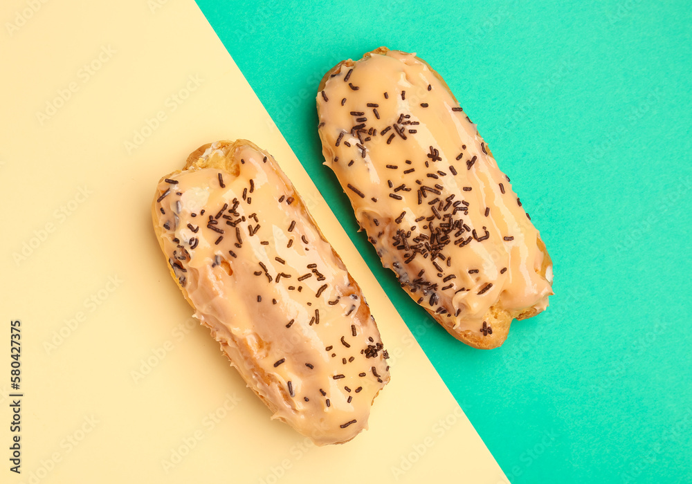 Tasty glazed eclairs on yellow and turquoise background