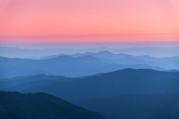 Wall Mural - Amazing silhouettes of a mountains at colorful sunset in summer in Ukraine. Landscape with mountain ridges in fog, pink sky in the evening. Nature background. Hills at twilight. Scenery