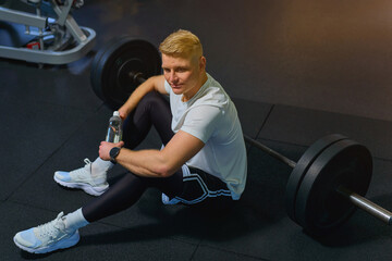 blonde guy is working out in the gym