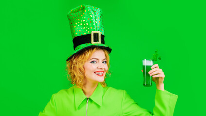 Woman celebrate Patricks Day. Beautiful girl in leprechaun hat drinking green beer in bar. Patrick Day pub party. Smiling girl holds glass of green beer with clover. Saint Patricks day or oktoberfest.