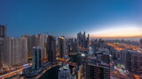 Fototapeta Londyn - Panorama of various skyscrapers in tallest recidential block in Dubai Marina aerial night to day timelapse