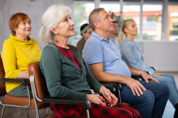 Older male and female students listening to lecture in university