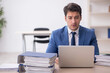 © Elnur - Young male employee and too much work in the office