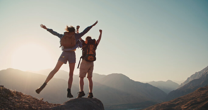 travel concept with happy couple at mountain top with raised arms and islands at background. place f