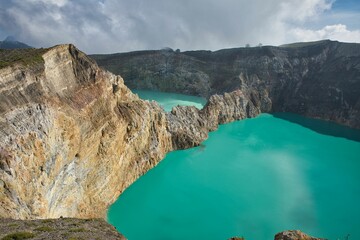 Panoramic view over the volcano Mount Kelimutu in Ende on Flores with its two sunlit turquoise crater lakes.