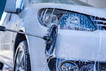 Sticker - Manual car wash with white soap, foam on the body. Washing Car Using High Pressure Water.