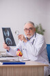 © Elnur - Old male doctor radiologist working at the hospital
