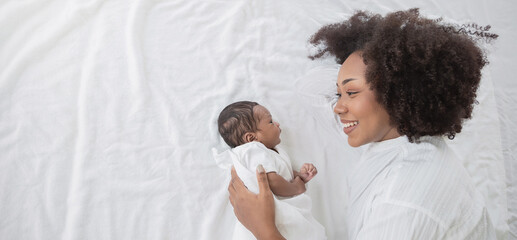closeup portrait of beautiful young african american mother day girl kiss healthy newborn baby sleep