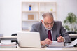 © Elnur - Old male employee working in the office