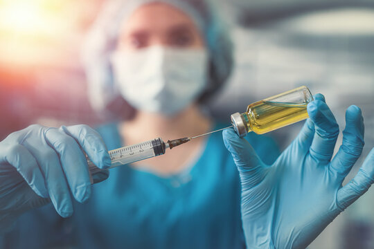 attractive female doctor holding syringe in operating room for patient.