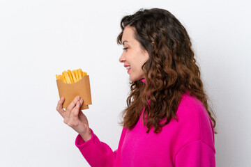 Canvas Print - Young caucasian woman catching french fries isolated on white background with happy expression