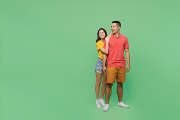 Full body smiling happy cool young couple two friends family man woman wear basic t-shirt together look aside on workspace area mock up isolated on pastel plain light green background studio portrait