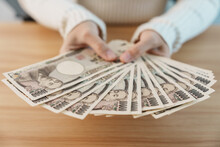 Woman Hand Counting Japanese Yen Banknote Over Table Background. Thousand Yen Money. Japan Cash, Tax, Recession Economy, Inflation, Investment, Finance, Savings, Salary And Payment Concepts