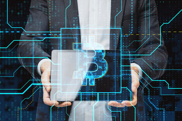 Wall Mural - Close up of businessman hand holding tablet with glowing circuit bitcoin hologram on dark background. Cryptocurrency and finance concept. Double exposure.