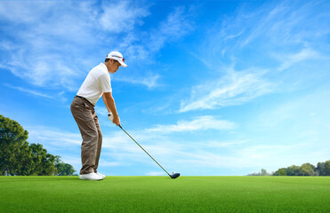 Wall Mural - Golf approach shot with driver on golfing ground with blue sky background.