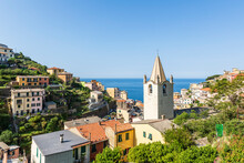 Italy, Liguria, Riomaggiore, Houses Of Coastal Town AlongCinqueTerre With Church Bell Tower In Foreground