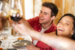 © Westend61 - Happy young man toasting wineglasses with friends at restaurant