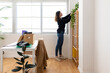 © Westend61 - Businesswoman decorating shelf in office