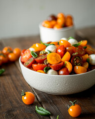 Fresh salad with red, yellow, orange cherry with fresh basil. Italian salad with fresh tomatoes. Vertical photo.