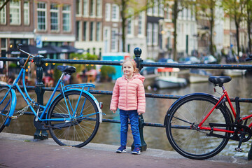 Wall Mural - Preschooler girl on a bridge in Amsterdam, the Netherlands