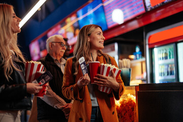 Diverse people in queue in movie theater.