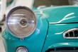 A close up look at teal classic car. Retro automobile exterior scene. Front view of old vehicle.