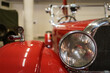 A close up look at red classic car. Retro automobile exterior scene. Front detail view of old vehicle.