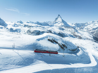 Wall Mural - Zermatt, Switzerland -The train of Gonergratbahn running to the Gornergrat station and observatory in the famous touristic place with clear view to Matterhorn.