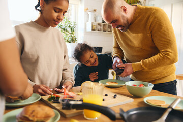 Wall Mural - Boy with Down syndrome having pancakes for breakfast with family