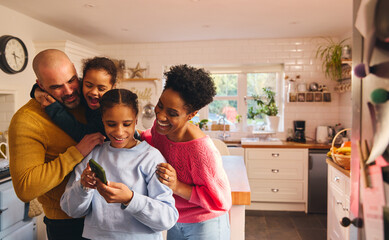 Wall Mural - Teen girl looking at selfie on phone with family