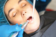© bedya - Closeup photo of male dentist with female patient in dental chair providing oral cavity treatment.