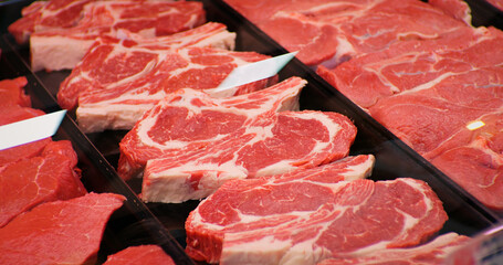 Wall Mural - Red rib eye meat for sale in meat department in a shop. Raw fresh meat ribeye for steak perfectly arranged in trays.