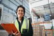© Jacob Lund - Female logistics manager smiling at the camera in a warehouse