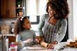 Mother Teaching Child to Bake and Help in the Kitchen. African American Mother and Daughter making cookies at home. 