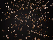 Aromatic Coffee Grains Dropping Against Brown Background