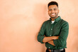 © Vadim Pastuh - Successful confident young indian male entrepreneur or businesswoman in casual clothes standing with arms folded over orange background, looking at the camera with attractive smile