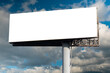 Mock up - blank wide white billboard or large advertising display against blue sky with white clouds. White screen, template, mock up, consumerism and copy space concept