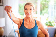 © gzorgz - Mid aged woman exercising with a power band at home
