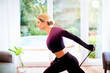 © gzorgz - Mid aged woman exercising with a power band at home