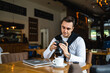 © Miljan Živković - one man use digital mirrorless camera while sit at cafe or restaurant
