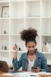 © Treerat - Smart African women working in beautiful office, working on Laptop, use the phone, talking on the cellphone.